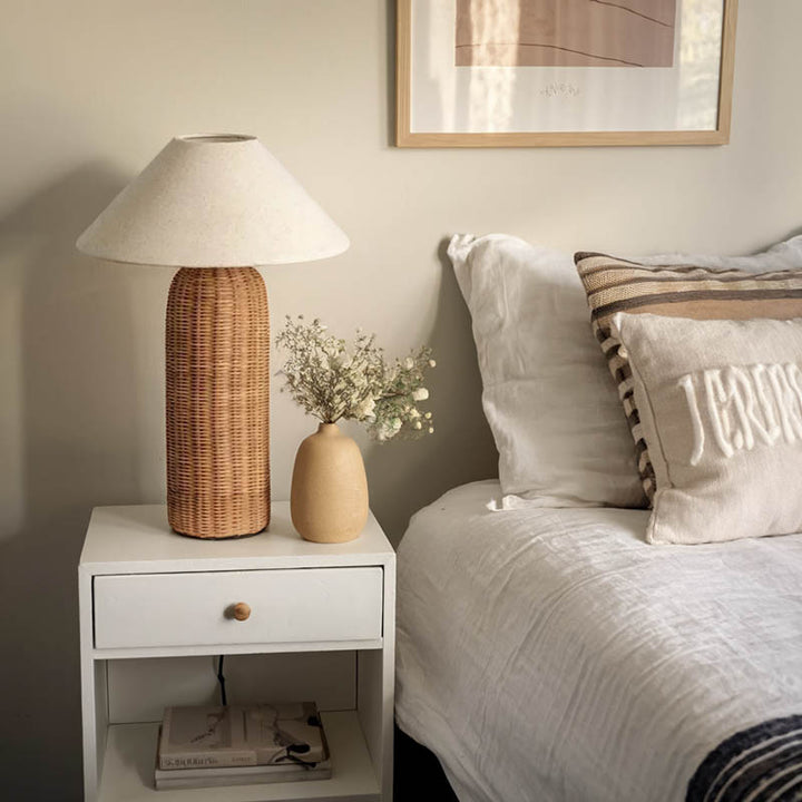Large LUN rattan lamp on bedside table, soft light in minimalist Nordic uk bedroom with neutral decor