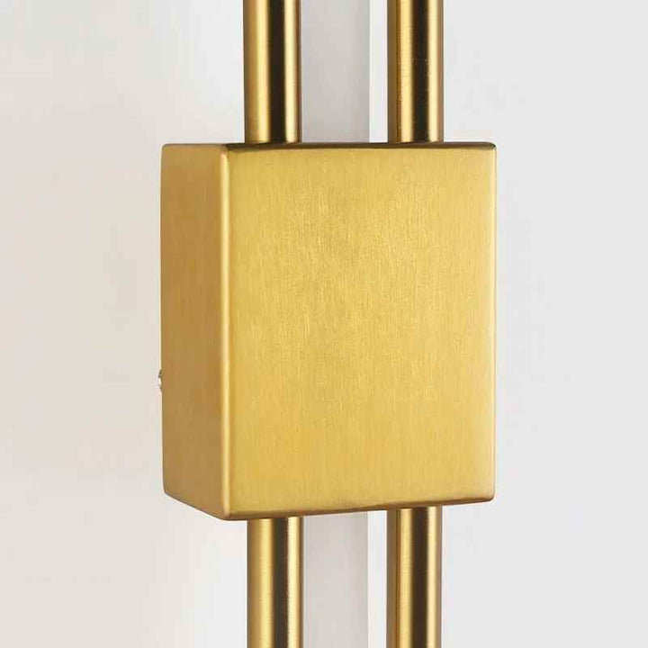 Close-up of brushed gold metal wall lamp base showing refined finish