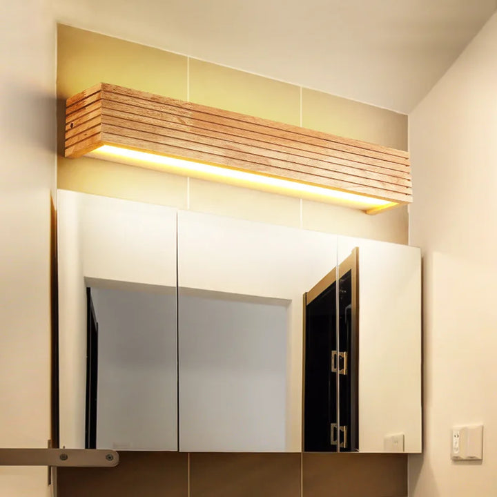 Elegant LYSE wooden LED wall lamp above mirror, providing bright bathroom lighting