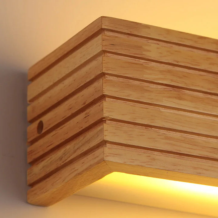 Close-up detail of LYSE wooden LED wall light with natural wood grain texture