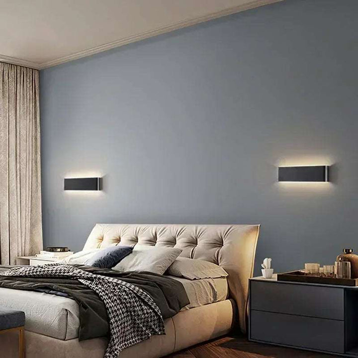 Pair of black LYST LED wall lamps mounted above bed in modern neutral bedroom interior