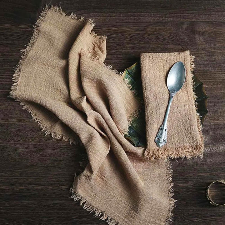 Rustic cotton gauze napkin in warm beige, 41 × 41cm, with frayed edges on a wooden table – perfect for Nordic-style dining.