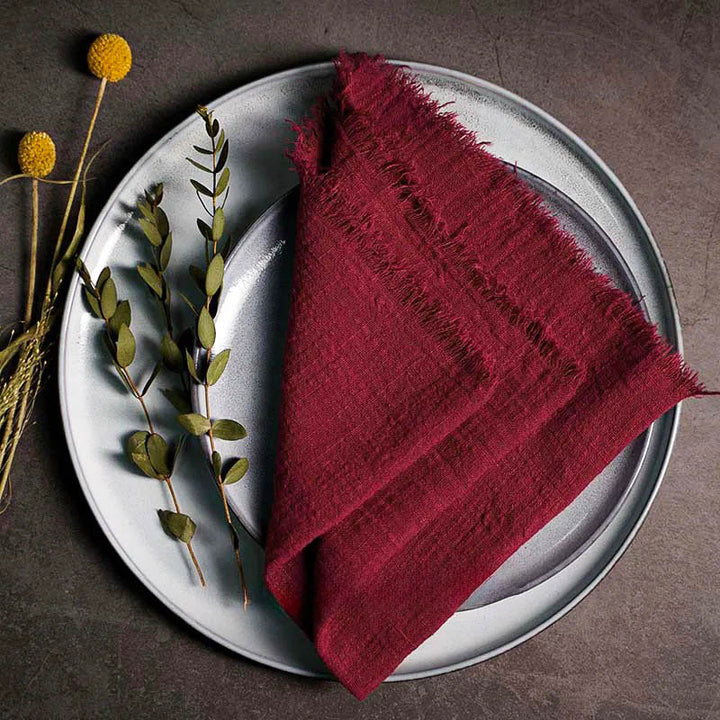 Burgundy cotton gauze napkin folded on ceramic plate with botanical accents, 41 × 41cm – soft and elegant for Scandinavian-style tables.