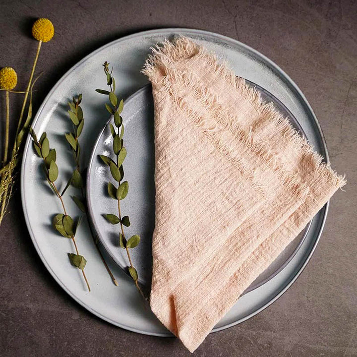 Peach cotton gauze napkin folded on ceramic plate with botanical accents,16 x 16 inches – soft and elegant for Scandinavian-style tables.