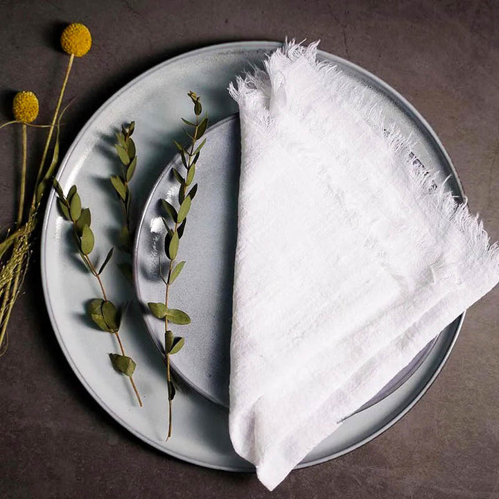 White cotton gauze napkin folded on ceramic plate with botanical accents, 41 × 41cm – soft and elegant for Scandinavian-style tables.