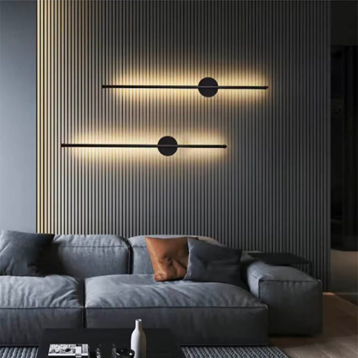Contemporary LED wall lamp in black with vertical bar design, paired with light-coloured modern furniture.