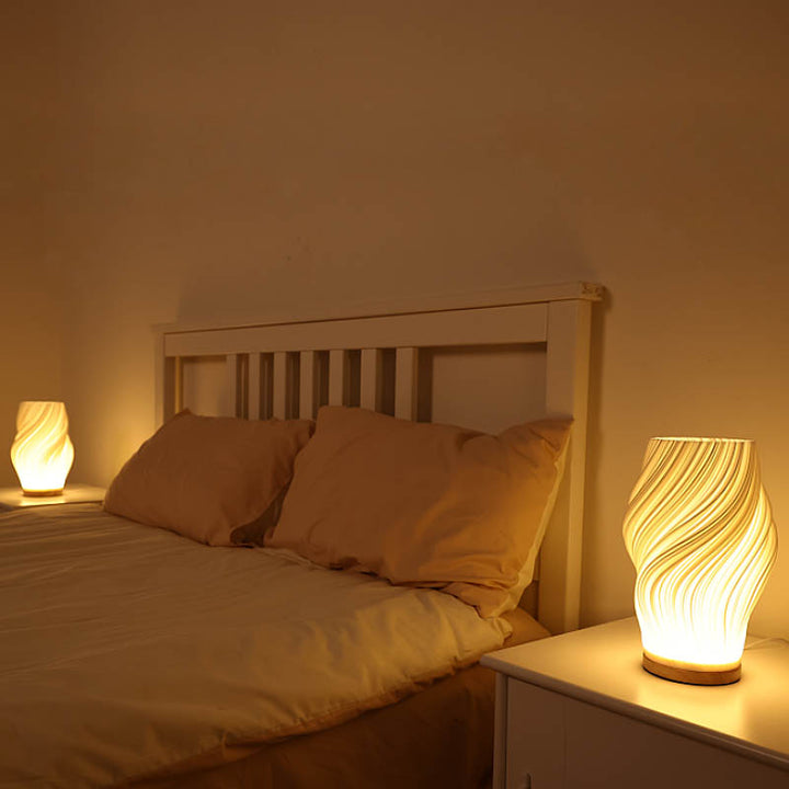 Pair of MOLLEN sculptural table lamps casting warm dimmable light on both sides of a modern wooden bed.