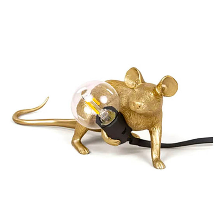 Gold mouse-shaped table lamp in lying position, holding LED bulb—quirky Art Deco accent light for modern interiors.