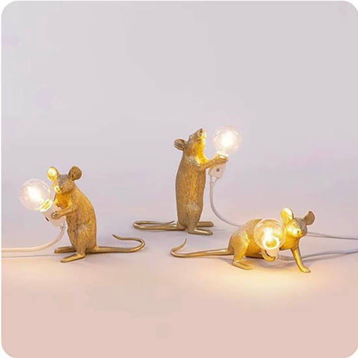 Set of three gold mouse table lamps in different poses, each holding a bulb—unique Art Deco lighting for shelves or desktops.
