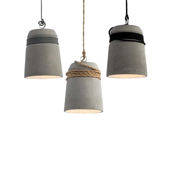 Three concrete pendant lights with varying design elements on a white background