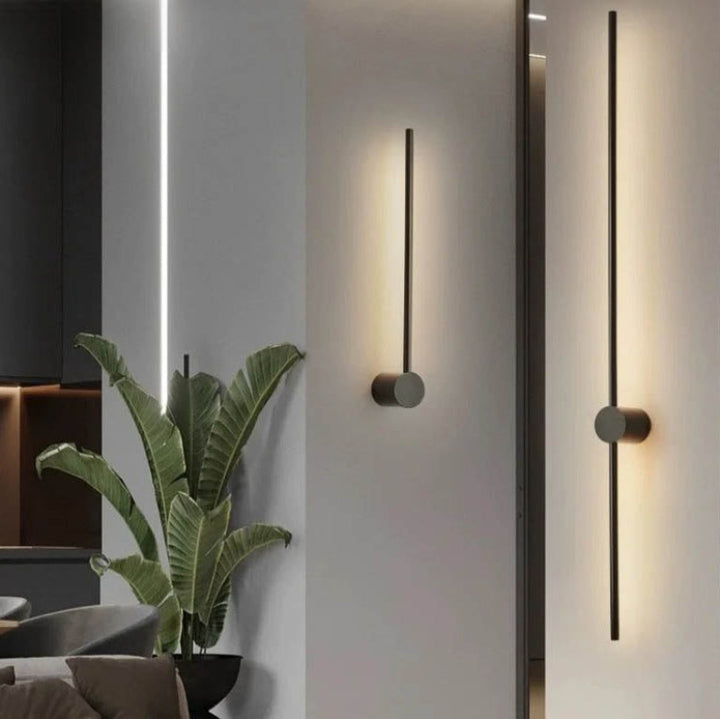 Slimline LED wall lamps mounted vertically by a staircase, casting warm ambient light in a Nordic-style UK interior.