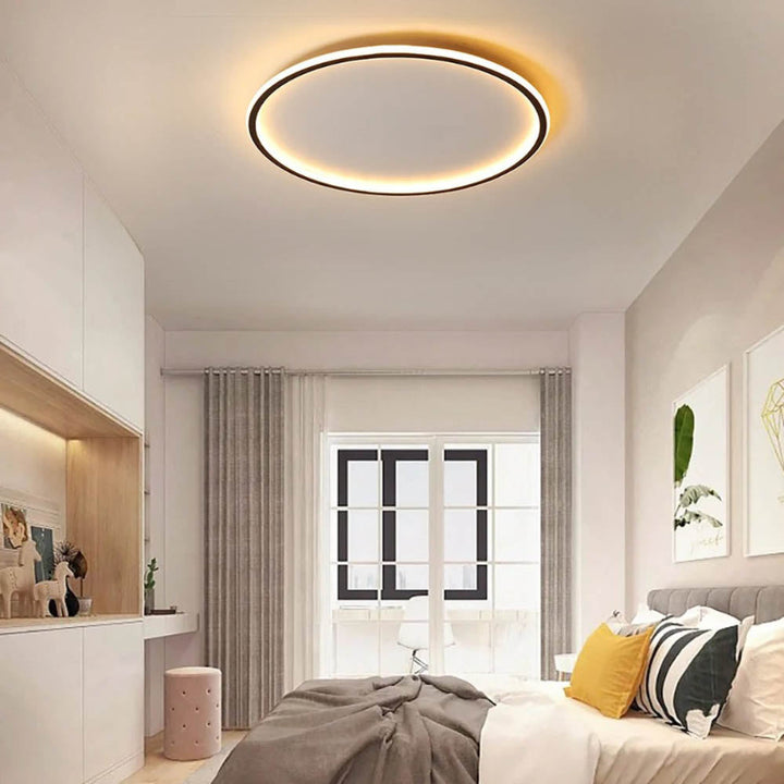 Nordic Essentials RUND LED ceiling light in black, 60cm, illuminating a modern bedroom with remote adjustable brightness.