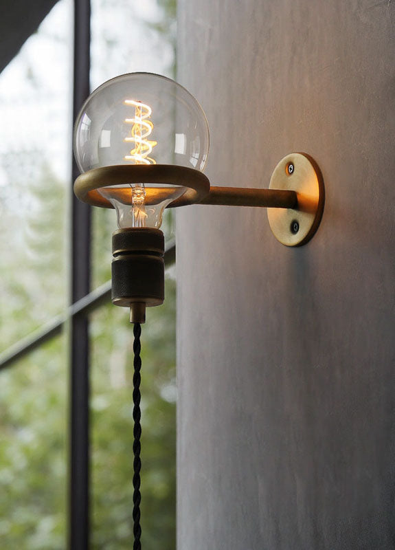 Wall-mounted light fixture with a visible bulb on a neutral background