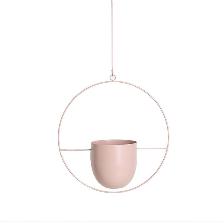 Pink hanging planter with a circular metal frame on a white background