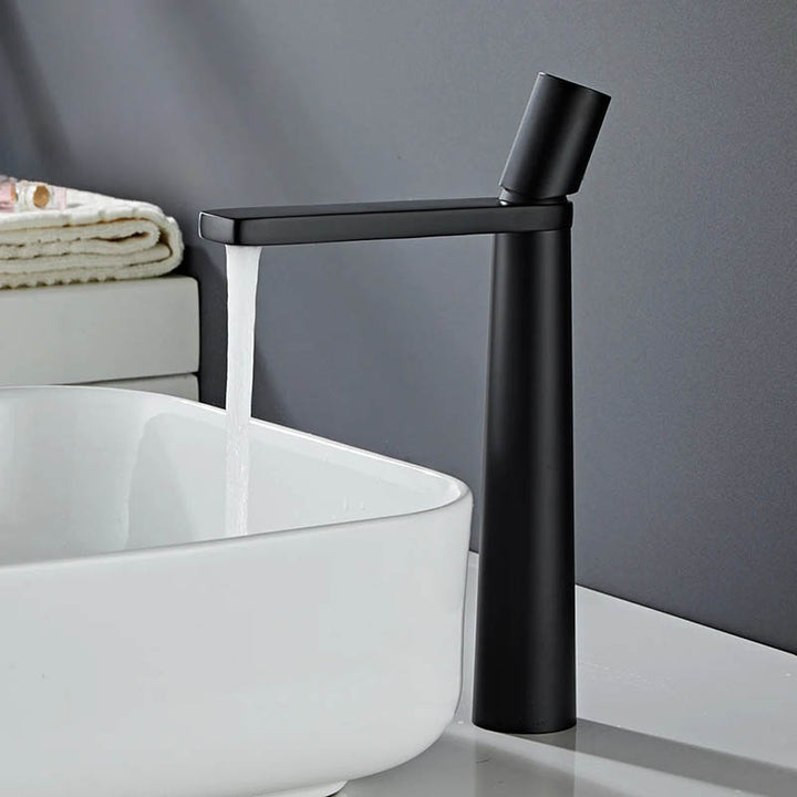 A modern high arch basin faucet with a chrome finish, positioned above a white sink, with a minimalist single-handle design.