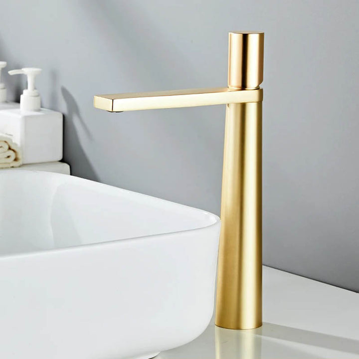 A modern high arch basin faucet with a chrome finish, positioned above a white sink, with a minimalist single-handle design.