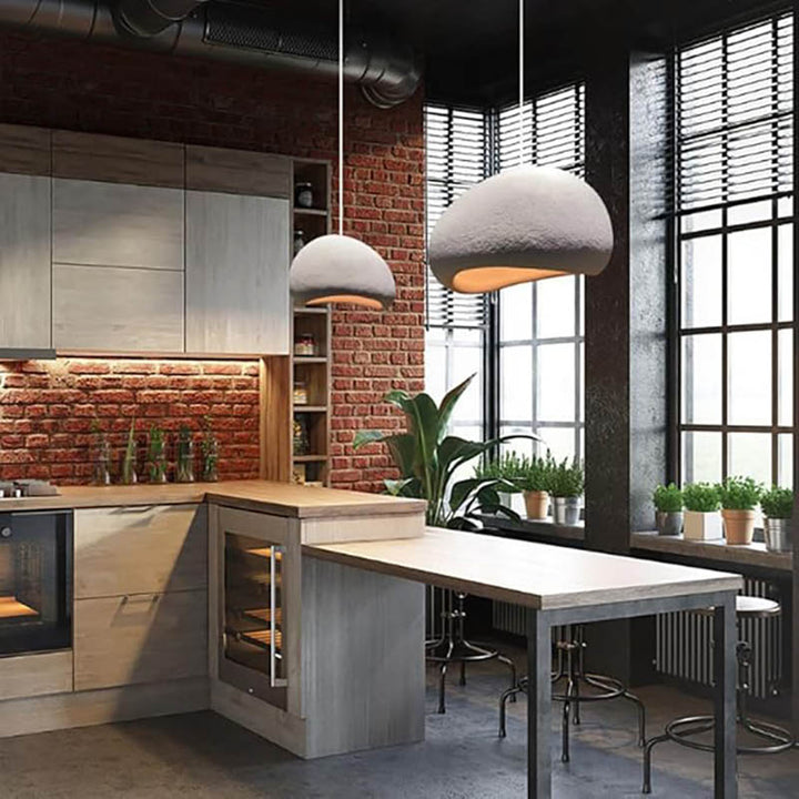 Two dome-shaped pendant lights installed in an industrial kitchen with brick wall and high ceiling
