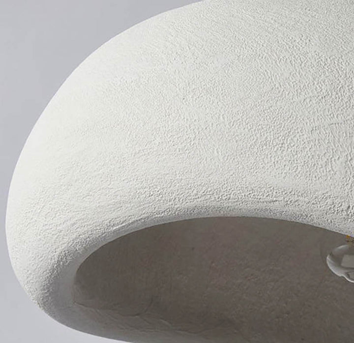 Close-up of the white HAETTE pendant lamp texture, showing curved cement-like finish and neutral tone