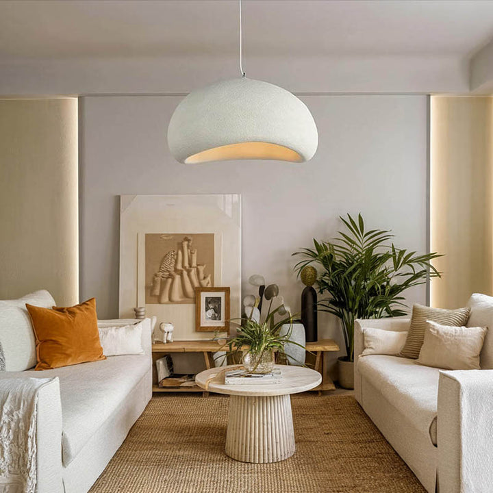 White HAETTE pendant light above a boho-style living room with warm neutral furniture