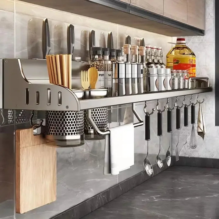 Modern kitchen storage rack with hanging utensils against a tiled wall.