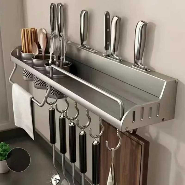Wall-mounted kitchen organizer with knives, utensils, and hooks on a neutral wall.