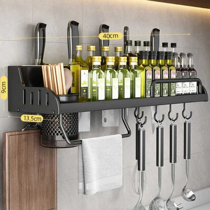 Wall-mounted kitchen shelf with utensils and bottles on a gray wall.