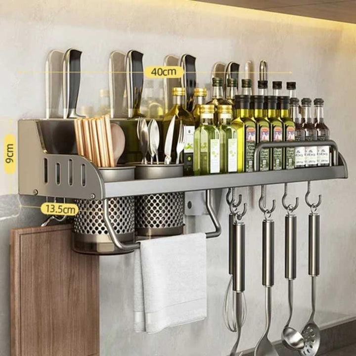 Wall-mounted kitchen shelf with utensils and bottles on a neutral wall.