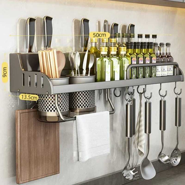 Kitchen wall organizer with utensils, bottles, and a paper towel holder.