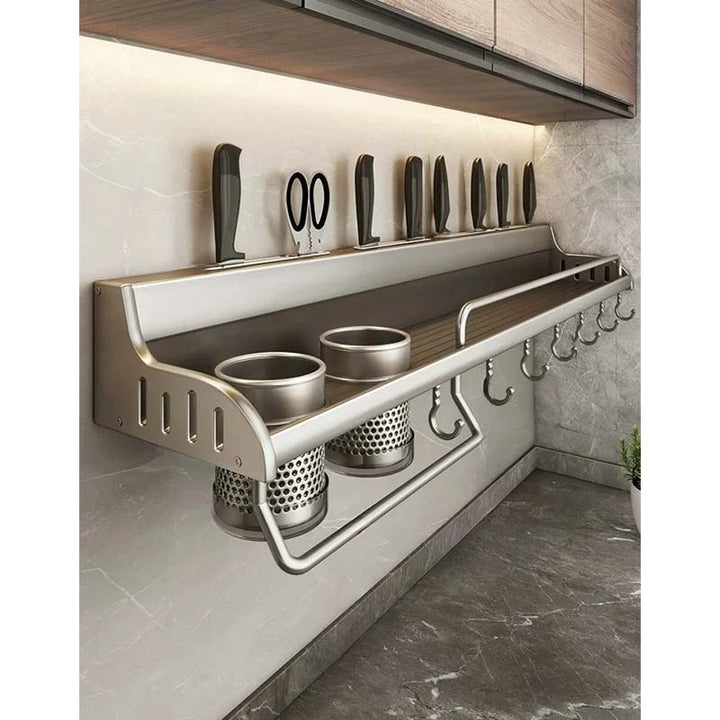 Wall-mounted kitchen utensil holder with knives and hooks on a tiled wall.