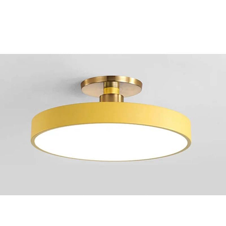 Ceiling light fixture with gold finish and white shade on a gray background