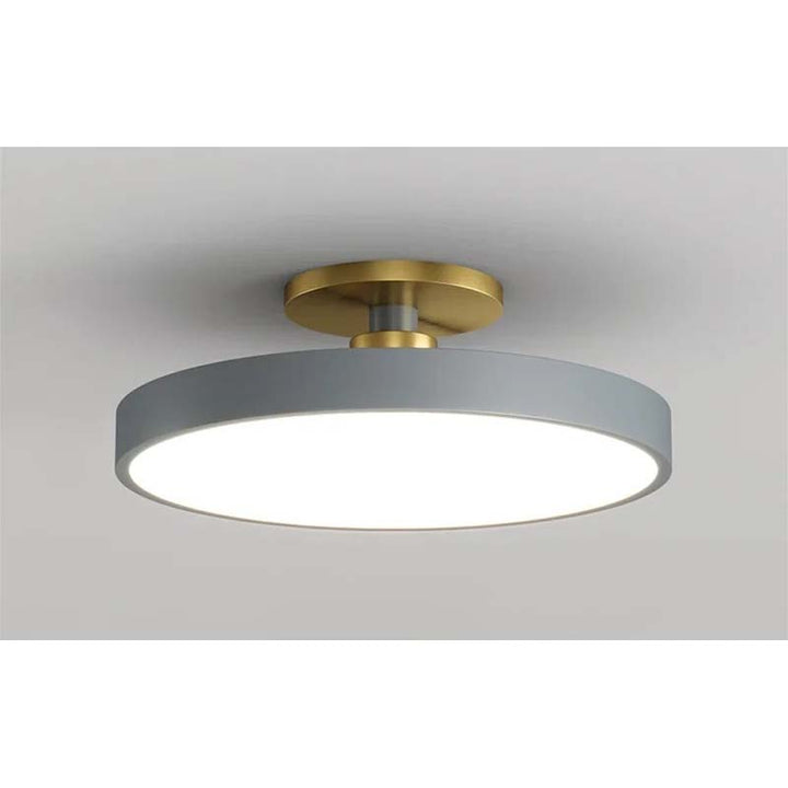 Ceiling light fixture with gold fixture and gray shade on a neutral background