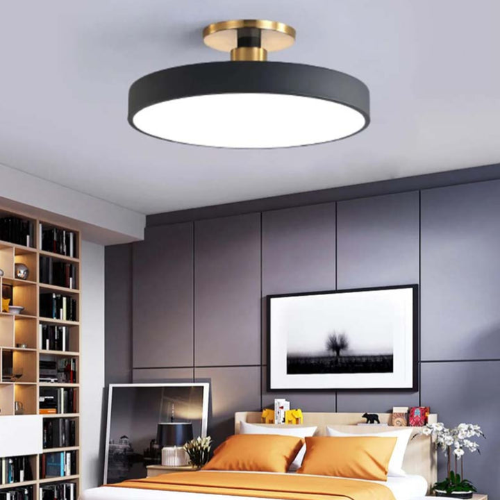 Modern bedroom with a black and gold ceiling light fixture.