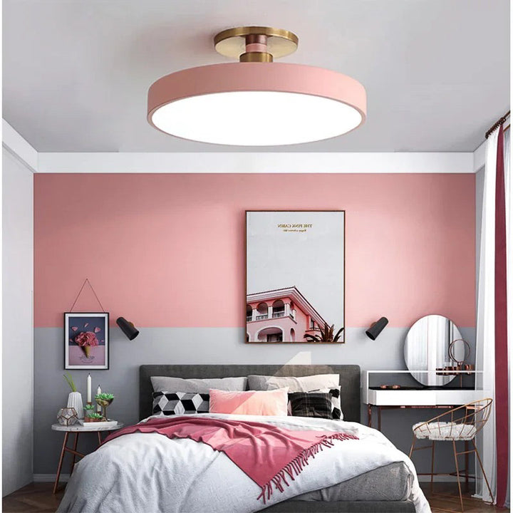 Modern bedroom with pink wall, ceiling light, and decor