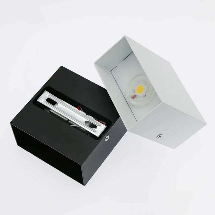 Black rectangular light fixture with a white square light fixture on a white background