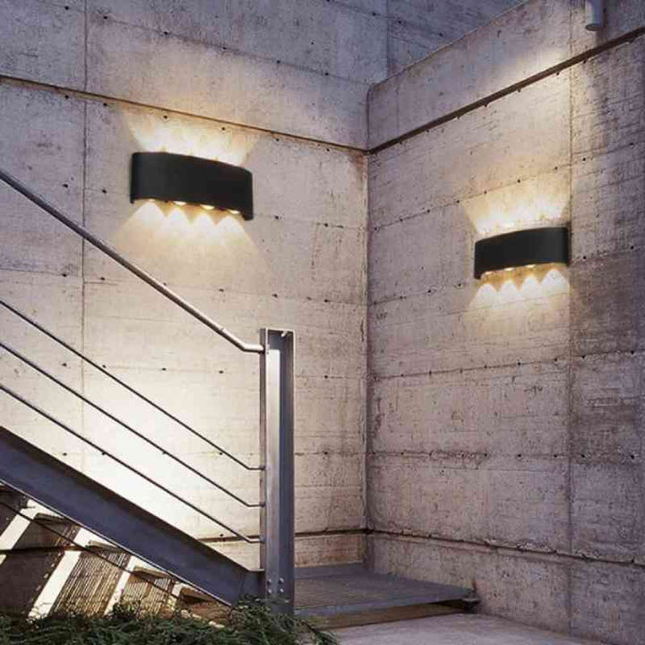 Two black aluminum modern LED wall lights illuminate outdoor concrete stairs, weatherproof for exterior.