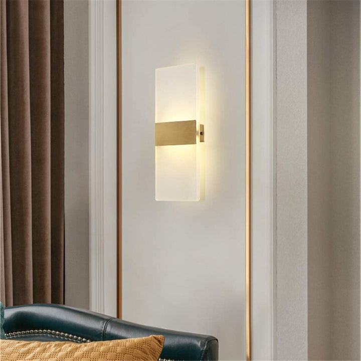 Modern wall sconce on a striped wall with a sofa in the foreground