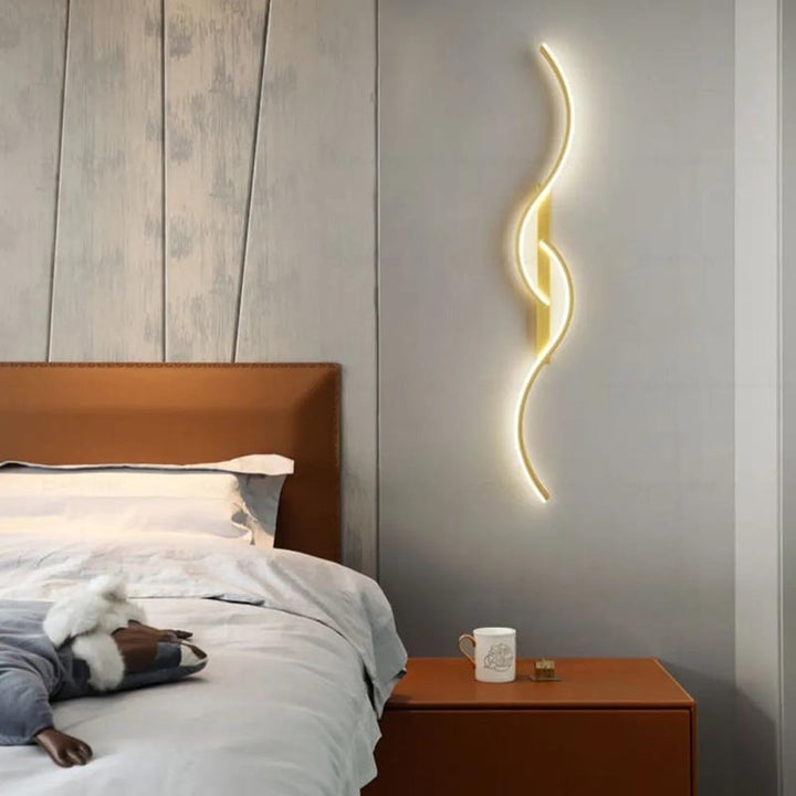 Minimalist gold LED wall light mounted beside bed, Nordic lighting with ambient bedroom glow