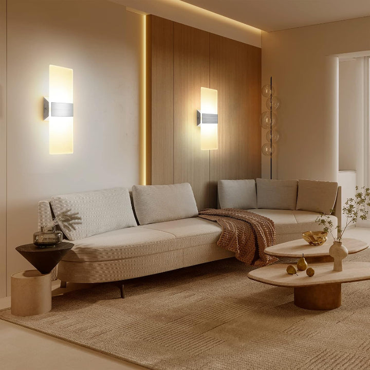 Modern living room with beige sofa, coffee table, and wall lights.
