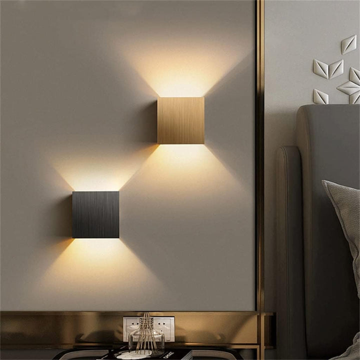 Modern wall lights on a neutral-colored wall with decorative elements.