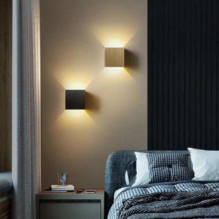 Modern bedroom with wall-mounted lights and a bed.