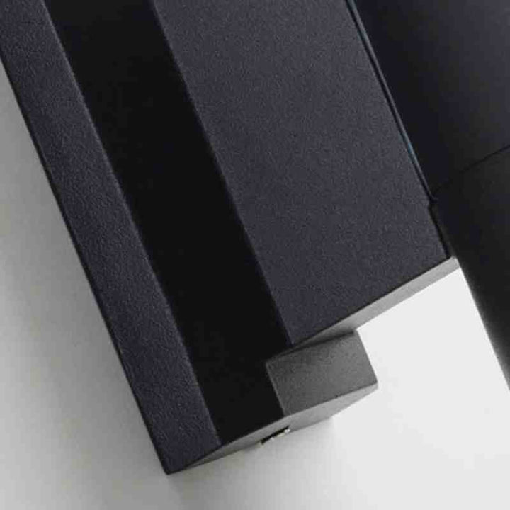 Close-up of matte black aluminum wall light base with durable textured finish.