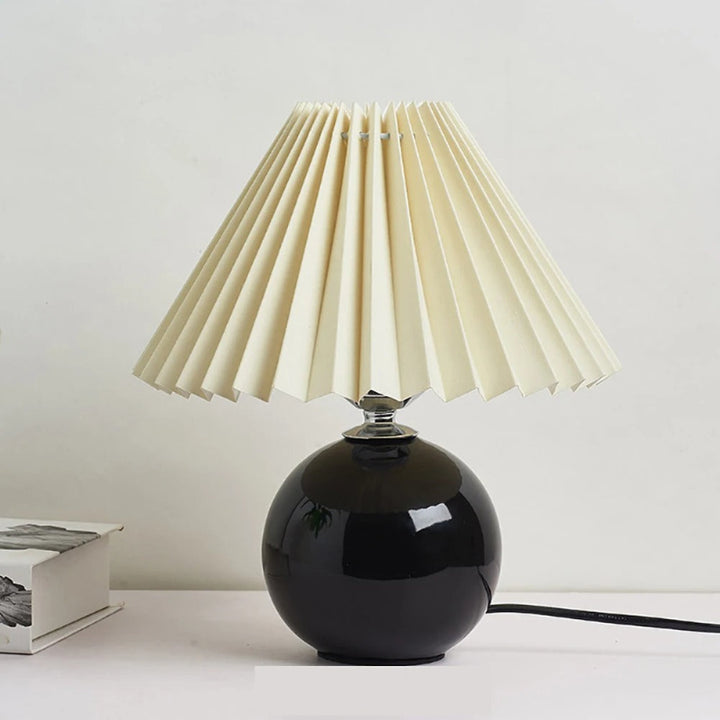 Black ceramic table lamp with crisp white pleated shade, decorative light for side tables or shelves.
