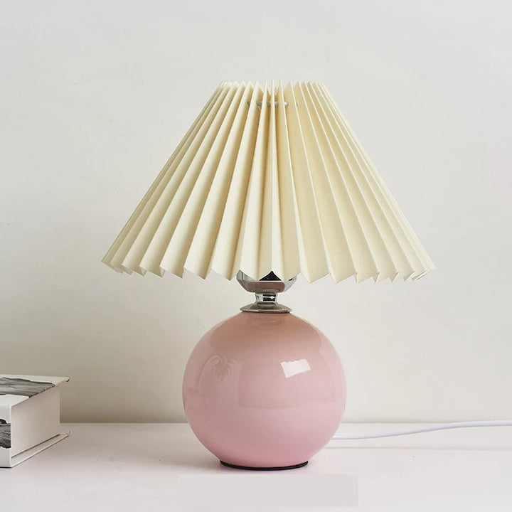 Soft pink ceramic table lamp with pleated fabric shade, perfect for calm Japandi-style interiors.
