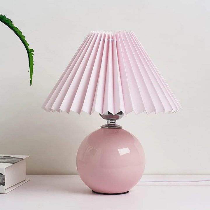 Ceramic table lamp with pink pleated fabric shade, bold accent lighting for stylish interiors.