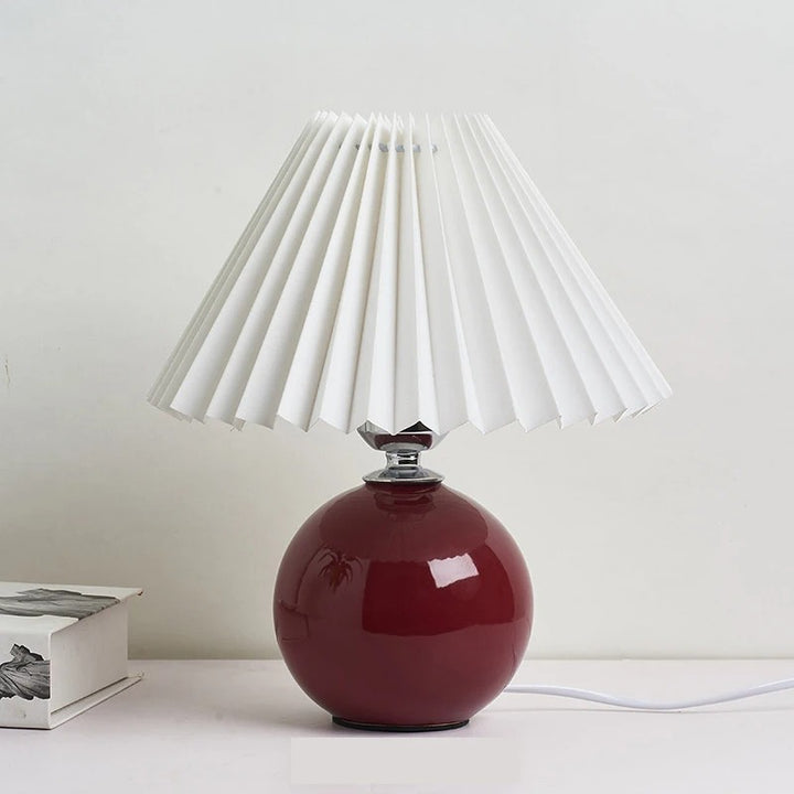Burgundy ceramic table lamp with crisp white pleated shade, decorative light for side tables or shelves.