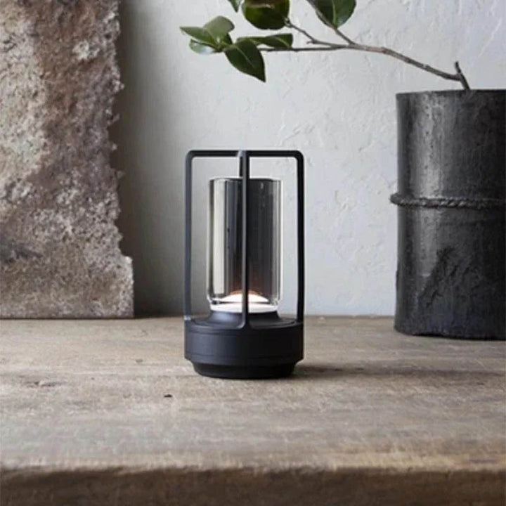 Compact black KRYSTAL cordless table lamp beside vase, perfect for UK Scandinavian-style interiors.