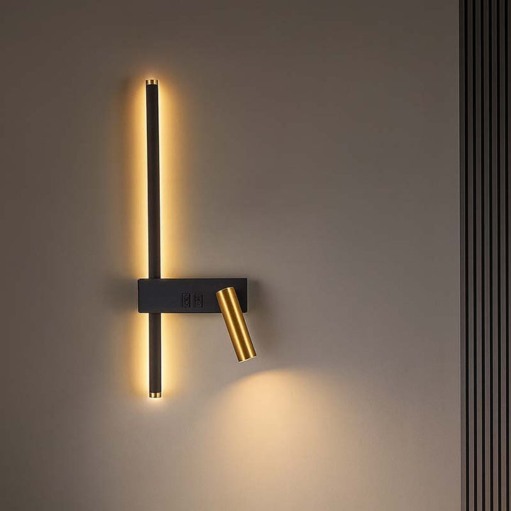 Modern wall sconce with black and gold design on a neutral wall.