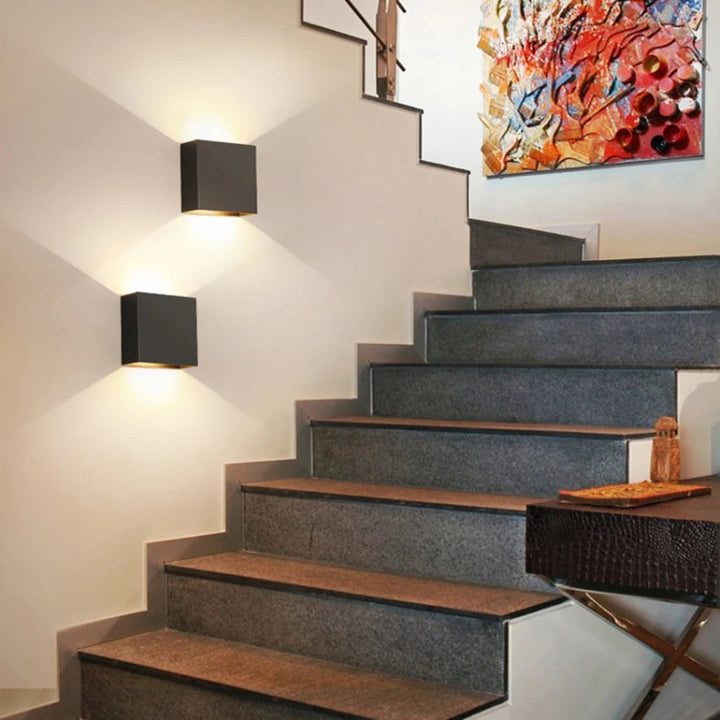 Staircase with modern design, wall lights, and a colorful abstract painting.
