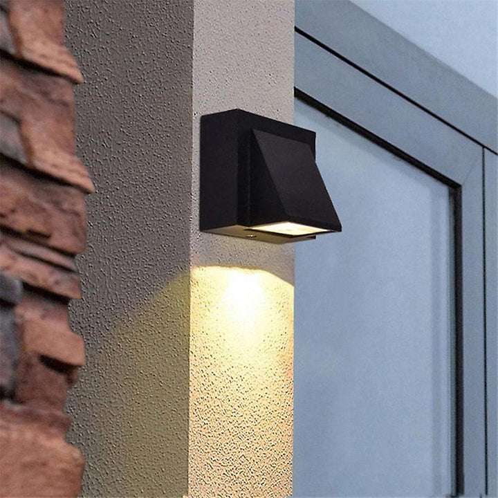 Black outdoor LED wall light fixture on a building exterior.