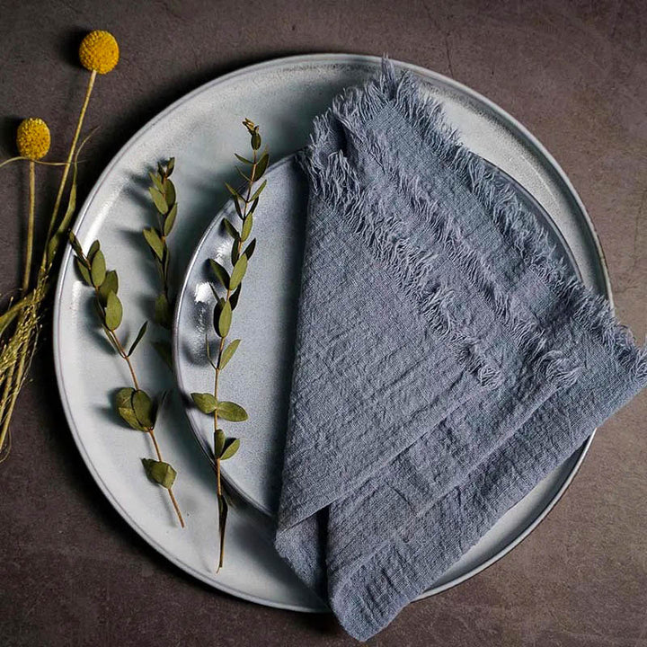 Blue grey cotton gauze napkin folded on ceramic plate with botanical accents, 41 × 41cm – soft and elegant for Scandinavian-style tables.